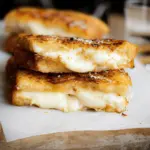 Delicious golden Italian Mozzarella in Carrozza with marinara dipping sauce and fresh basil, a comforting Italian recipe.