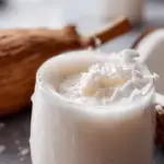 Refreshing coconut cooler served in a coconut shell with tropical fruits and mint leaves, ideal for summer hydration.